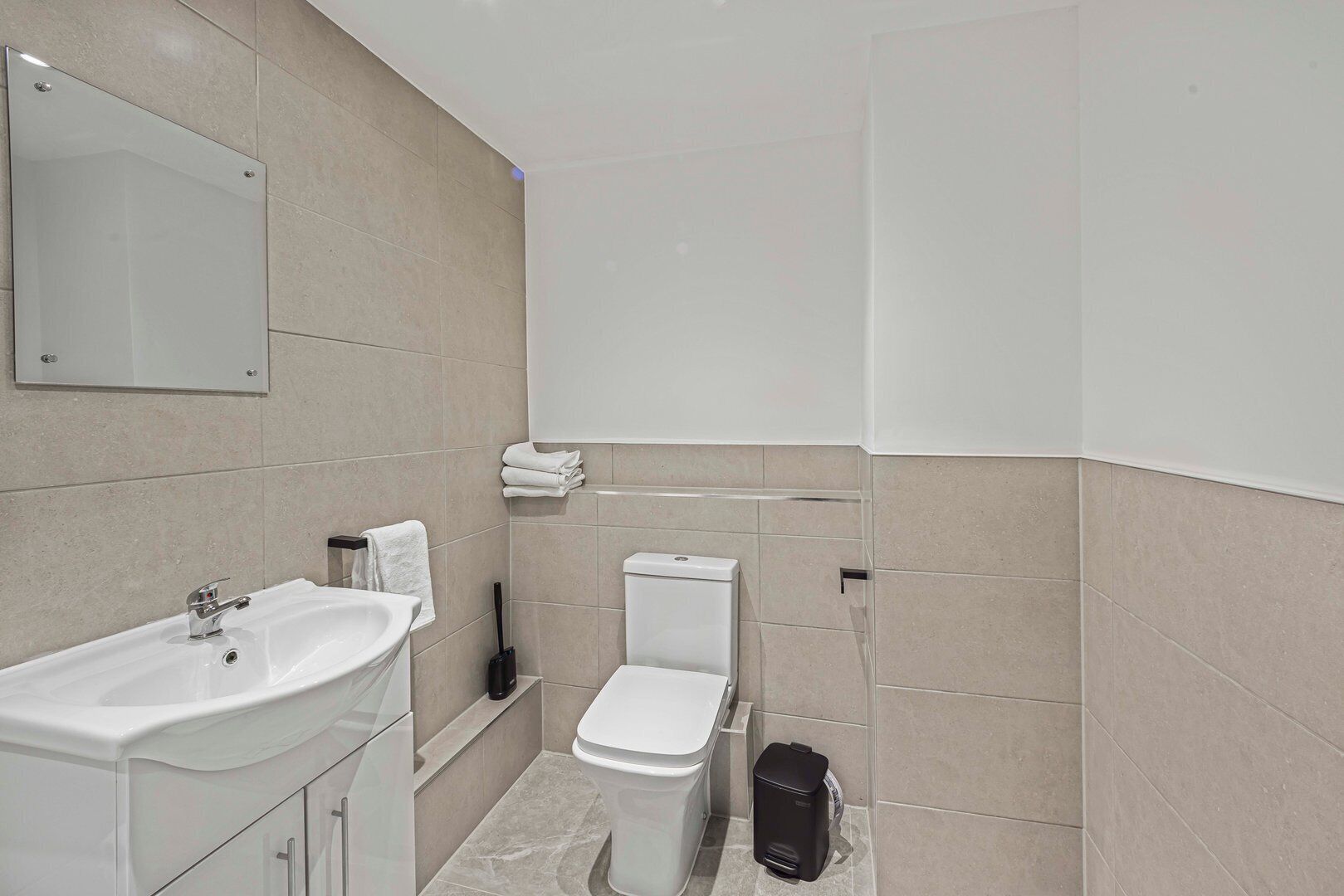 Ein modernes Badezimmer mit Waschbecken, Toilette und Spiegel.