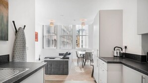 Uma cozinha moderna com área de refeições, apresentando um sofá, mesa e cadeiras.