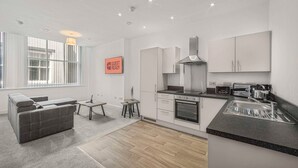 A modern kitchen with white cabinetry, a built-in oven, and a countertop with a sink.