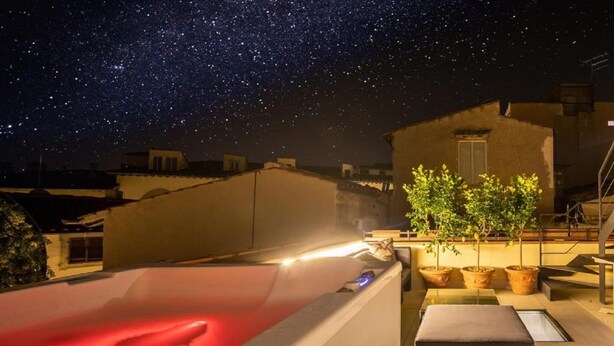A rooftop terrace with a red pool, potted plants, and a clear night sky. - Exclusive Florence Getaway with Jacuzzi, Terraces & Concierge Services (Firenze)