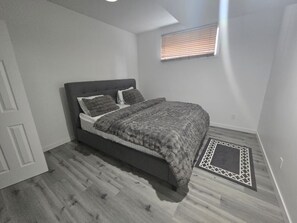 A bedroom with a bed, a window, and a door. - Tranquil 1-bedroom appartement in the basement South west of Edmonton (Edmonton)