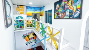 Una escalera con barandas de colores y un mural que muestra peces tropicales.