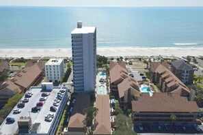 A coastal hotel with a tall central building, multiple smaller buildings, a parking lot, and a beach view. - Ocean View 3BR-Forest Dunes 1403-Pools & Hot Tub (Myrtle Beach)