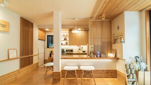 A modern interior with wooden flooring, a reception desk, white bar stools, and a wooden slat wall.