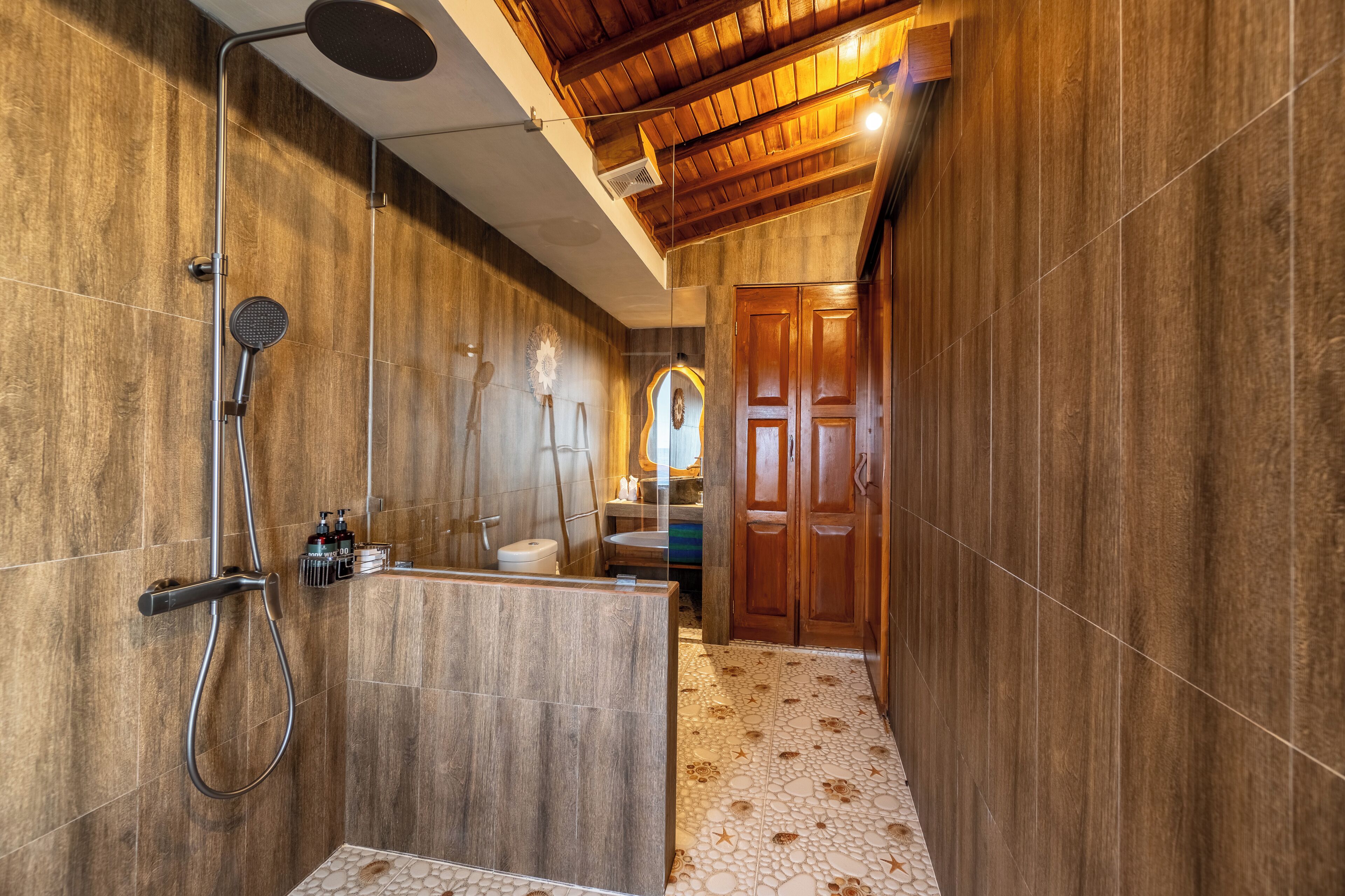A modern bathroom with a shower, vanity, and wooden ceiling.