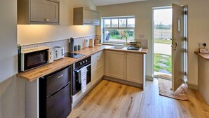 A modern kitchen with a microwave, toaster, oven, and sink. - Cottage in Hemingby Near Lincolnshire Wolds (Horncastle)