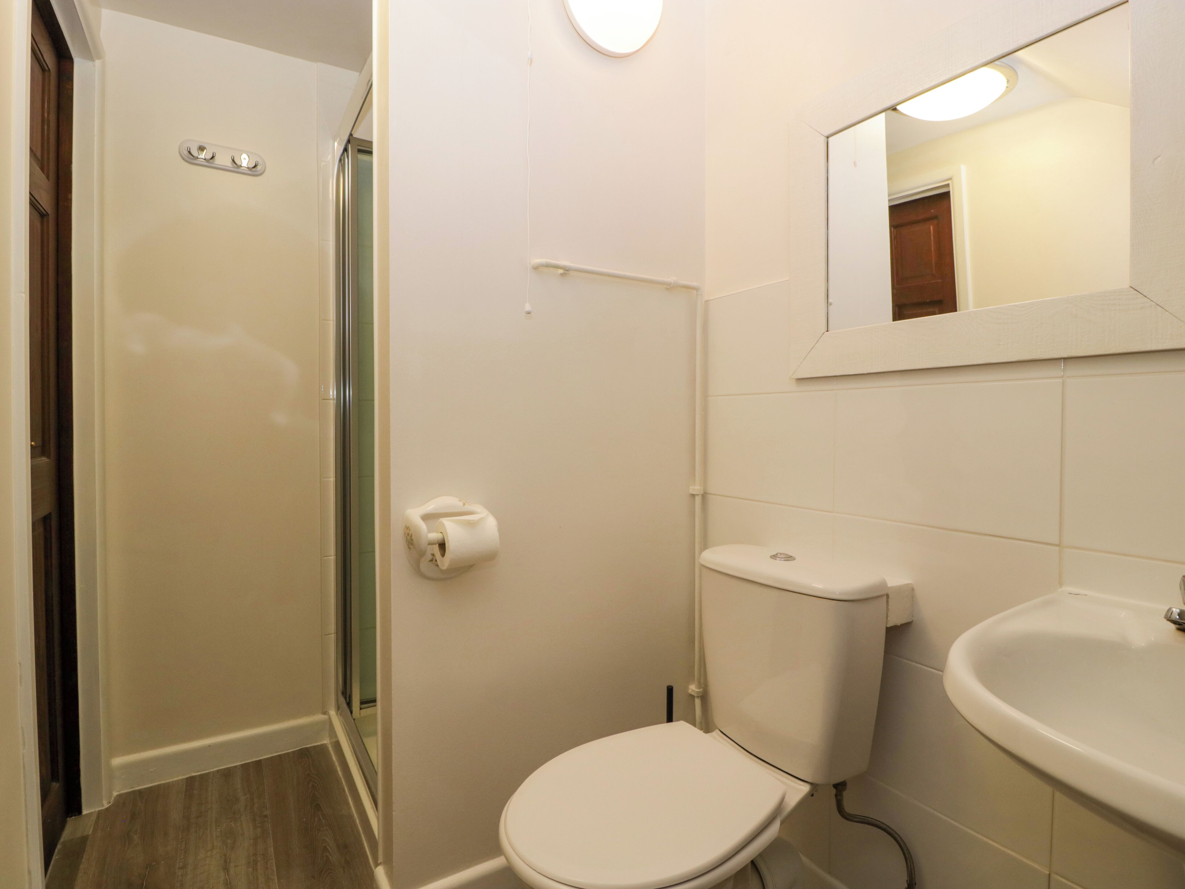 A bathroom with a toilet, sink, and shower.