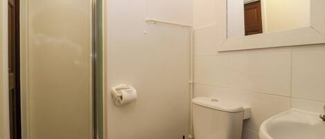 A bathroom with a toilet, sink, and shower.