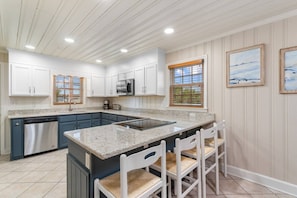 A kitchen with white cabinets, a granite countertop, and a stainless steel dishwasher. - 5 BR Dog Friendly Home- Slps 12- Steps from sand (North Myrtle Beach)