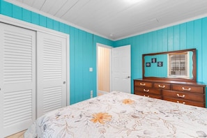 A bedroom with a bed, a dresser, a mirror, and a door. - 5 BR Dog Friendly Home- Slps 12- Steps from sand (North Myrtle Beach)