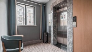Ein Hotelzimmer mit Marmorelevator, einem fensterartigen Ausblick und einem gemusterten Boden.