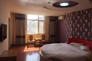 A hotel room with a bed, a desk, and a chair. There is a window with curtains, and an air conditioning unit on the wall. - Xinle Dekaiyuan Express Hotel (Xinle)