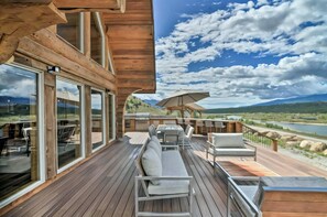 A wooden deck with outdoor seating and a view of a lake and mountains. - 4 BR Luxury Lakefront Cabin w/ Mtn Views (Lake County)