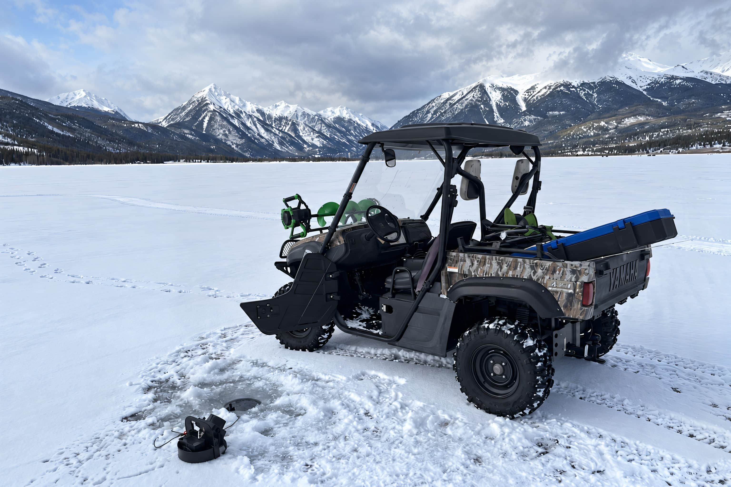 A snowmobile on a frozen lake with mountains in the background.