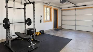 Una palestra in casa con una rack per squat, una panca e bilancieri.