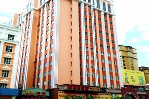 Un hotel de varios pisos con fachada uniforme, numerosas ventanas y entrada a nivel de calle con señalización.
