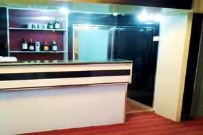 A reception desk with a counter, a refrigerator, and a shelf with bottles. - Manzhouli Taiyangsheng Inn (Manzhouli)