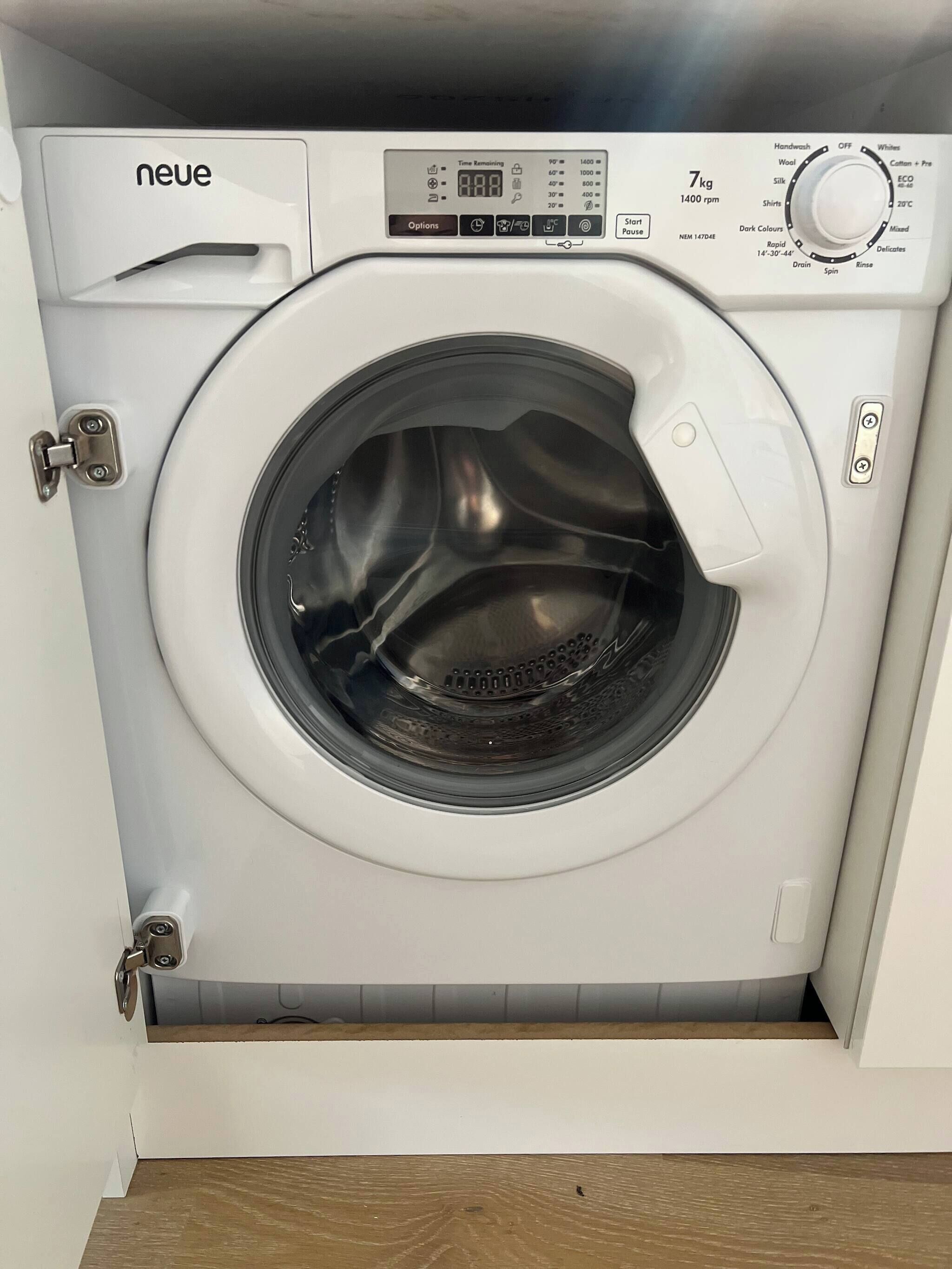 A front view of a front-loading washing machine with a control panel, a digital display, and a door.