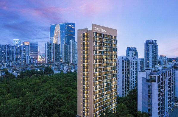 A high-rise hotel with multiple floors, a prominent 'citadines' sign, and a dense urban backdrop.