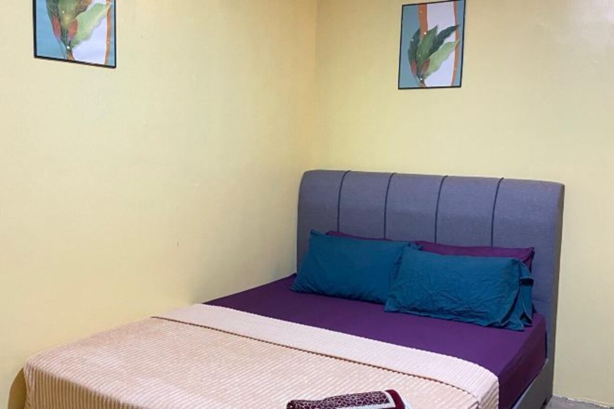 Un lit simple avec une tête de lit, deux oreillers et une couvre-lit.
