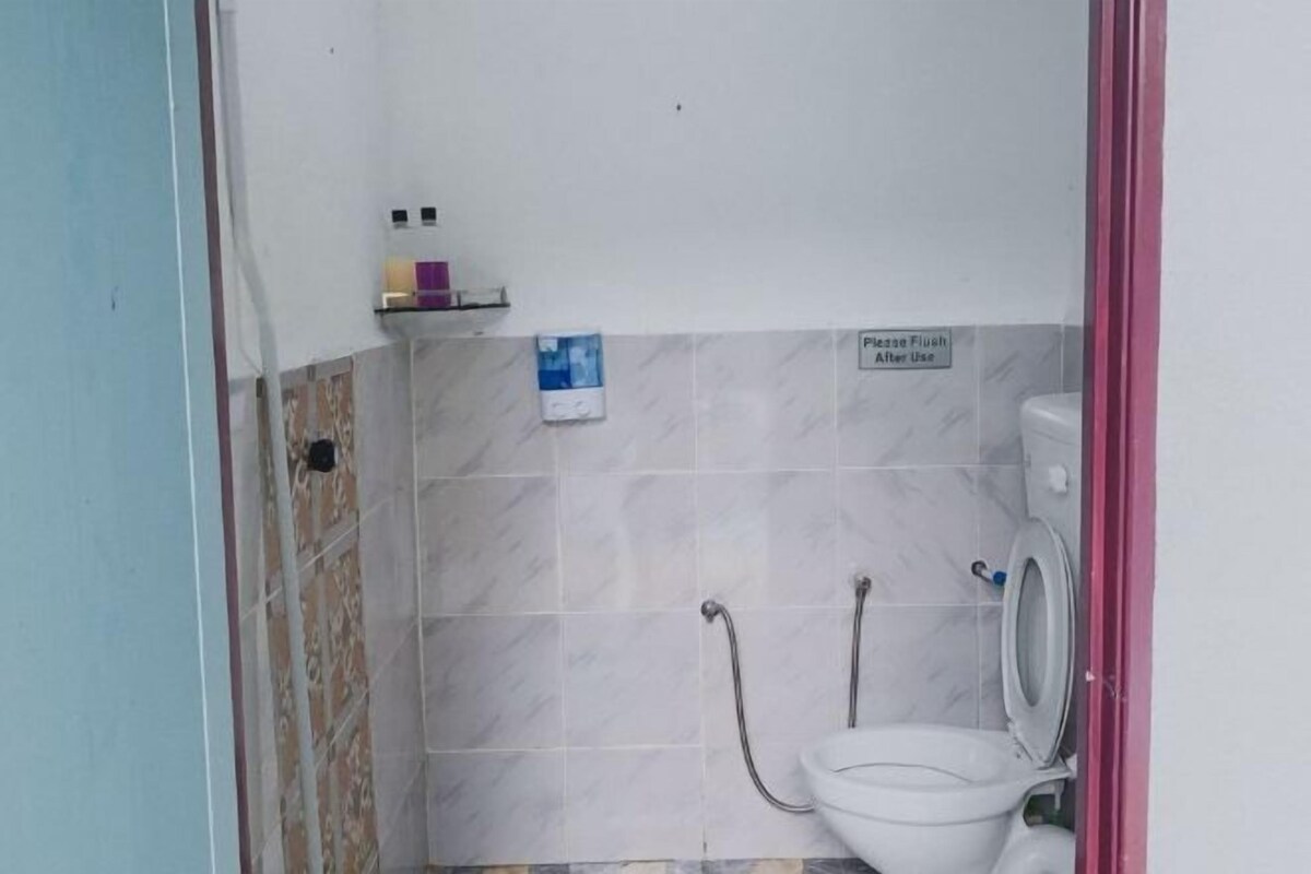 Un baño pequeño con inodoro, ducha y un letrero que dice 'Por favor, tire de la cadena después de usar'.