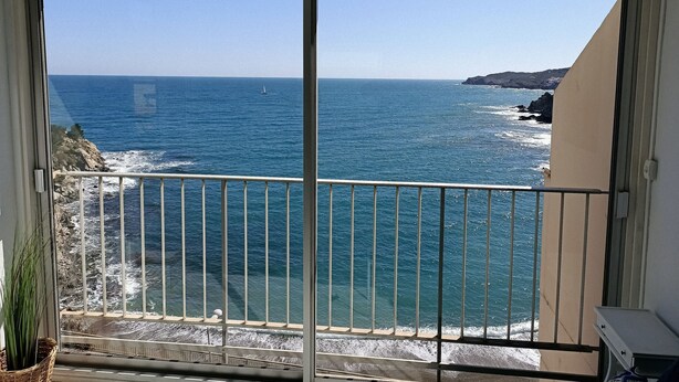 Un balcón con vista al mar y a la costa rocosa.
