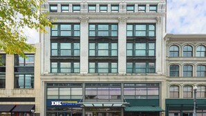 A multi-story building with large windows and a sports store on the ground floor.