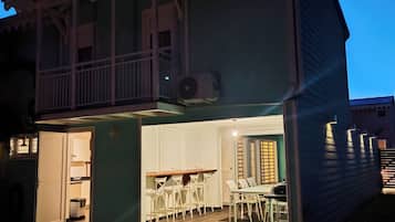 A two-story house with a balcony, a dining area, and a small pool.