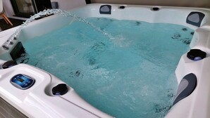Ein Whirlpool mit digitaler Steuerung, einer Wasserpumpe und einer integrierten Sitzgelegenheit.
