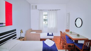 Ett hotellrum med två sängar, ett matbord och en stol.