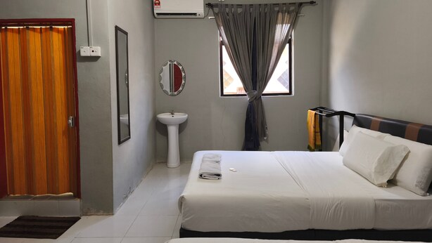 A hotel room with a bed, a sink, a mirror, an air conditioning unit, and a window with curtains. - Hotel O Selesa Inn (Kuala Berang)