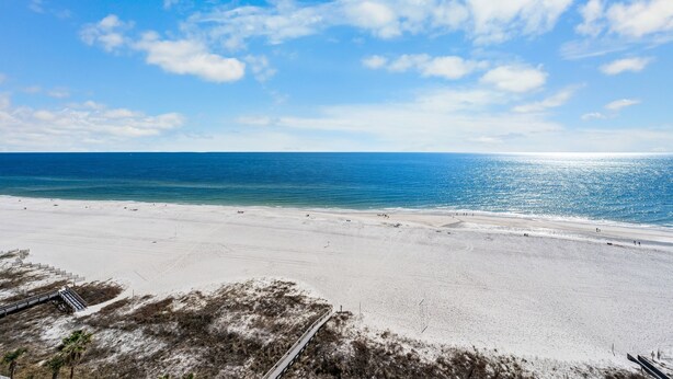 Een strand met heldere lucht en een rustige zee.