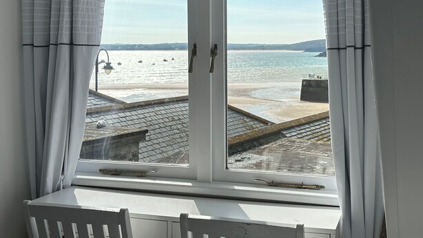 A room with a large window overlooking a beach and the sea. - Seahorse Cottage (St Ives)