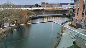 A modern building with a glass facade overlooking a calm river. - Dartford Apartment - Sleeps 3 - Central Stay (Dartford)