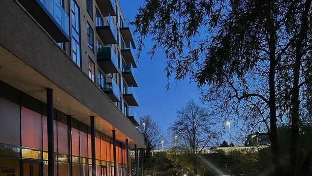 A modern building with a glass facade, a covered walkway, and a well-lit entrance. - Dartford Apartment - Sleeps 3 - Central Stay (Dartford)