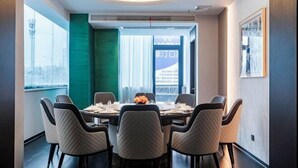 A modern dining area with a round table, six chairs, and a vase of flowers. - Hehuaju Hotel (Chuzhou Suning Plaza) (Chuzhou)
