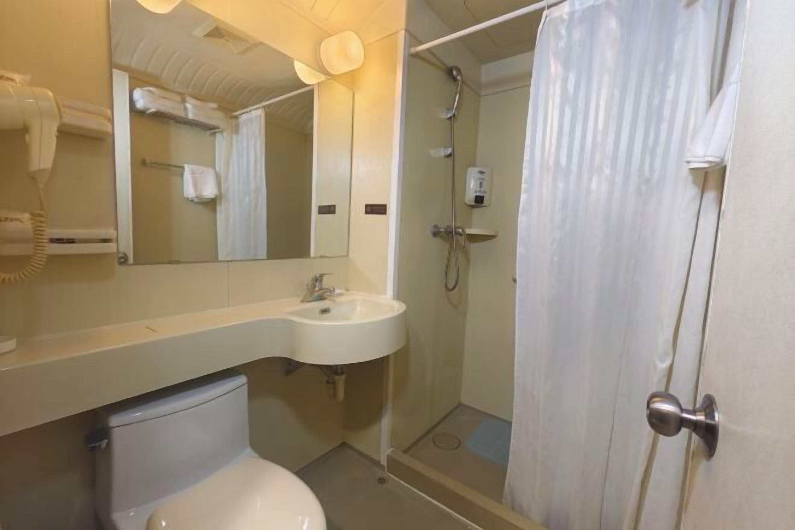 Ein Badezimmer mit Toilette, Waschbecken und Duschbereich.