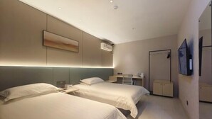 A hotel room with two beds, a desk, a chair, a TV, and a wardrobe. - Hehuaju Hotel (Chuzhou Suning Plaza) (Chuzhou)
