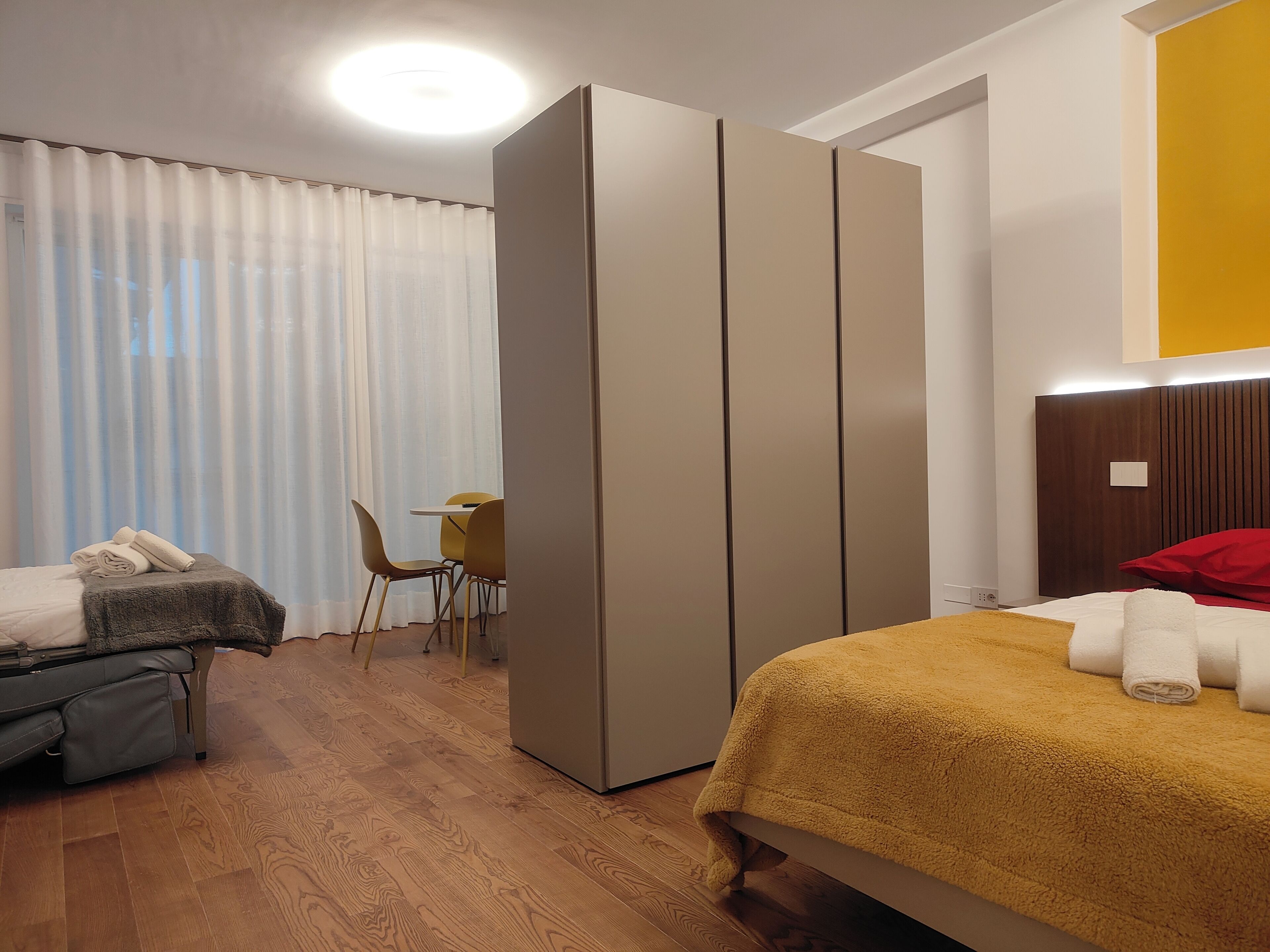 Hotellihuone, jossa on sänky, työpöytä, tuoli ja vaatekaappi.