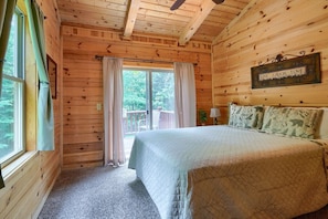A wooden cabin bedroom with a bed, curtains, a window, and a sign saying "LIVE LAUGH LOVE". - Buckeye Trail | Hocking Hills, 5BR, Hot Tub, Pets (Rockbridge)