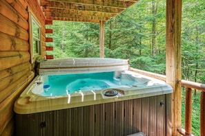 A hot tub on a wooden deck with a forest view. - Buckeye Trail | Hocking Hills, 5BR, Hot Tub, Pets (Rockbridge)