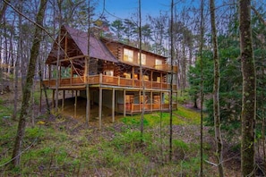A log cabin with a two-story structure, a porch, and a deck. - Buckeye Trail | Hocking Hills, 5BR, Hot Tub, Pets (Rockbridge)