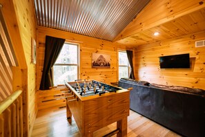 Ein Holzinterieur mit einem Kicker, einer Couch und einem Fernseher.
