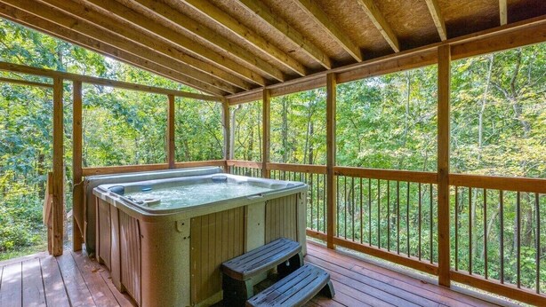 A hot tub on a wooden deck with a view of a forest. - Hideaway Cabin | Hocking Hills, 7 Private Acres (Logan)