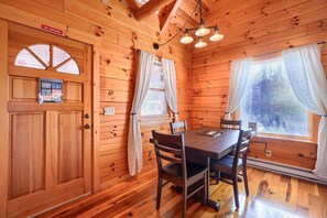 A wooden cabin with a dining area, a 'No Smoking' sign, and a window with blinds.