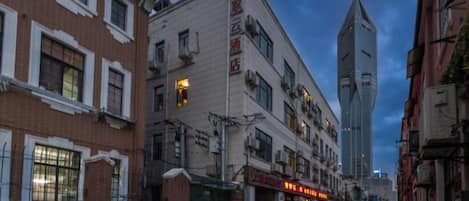 A street view with a building featuring a sign that reads 'Hotel.'