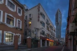 Une vue de rue avec un bâtiment sur lequel on peut voir une enseigne indiquant « Hôtel ».