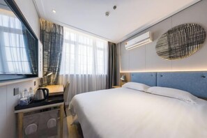 A modern hotel room with a bed, bedside table, lamp, air conditioning unit, and a window with curtains. - Homeinn Pebble Hotel (Shanghai Nanjing Road Pedestrian Street Jiangyin Road) (Shanghai)