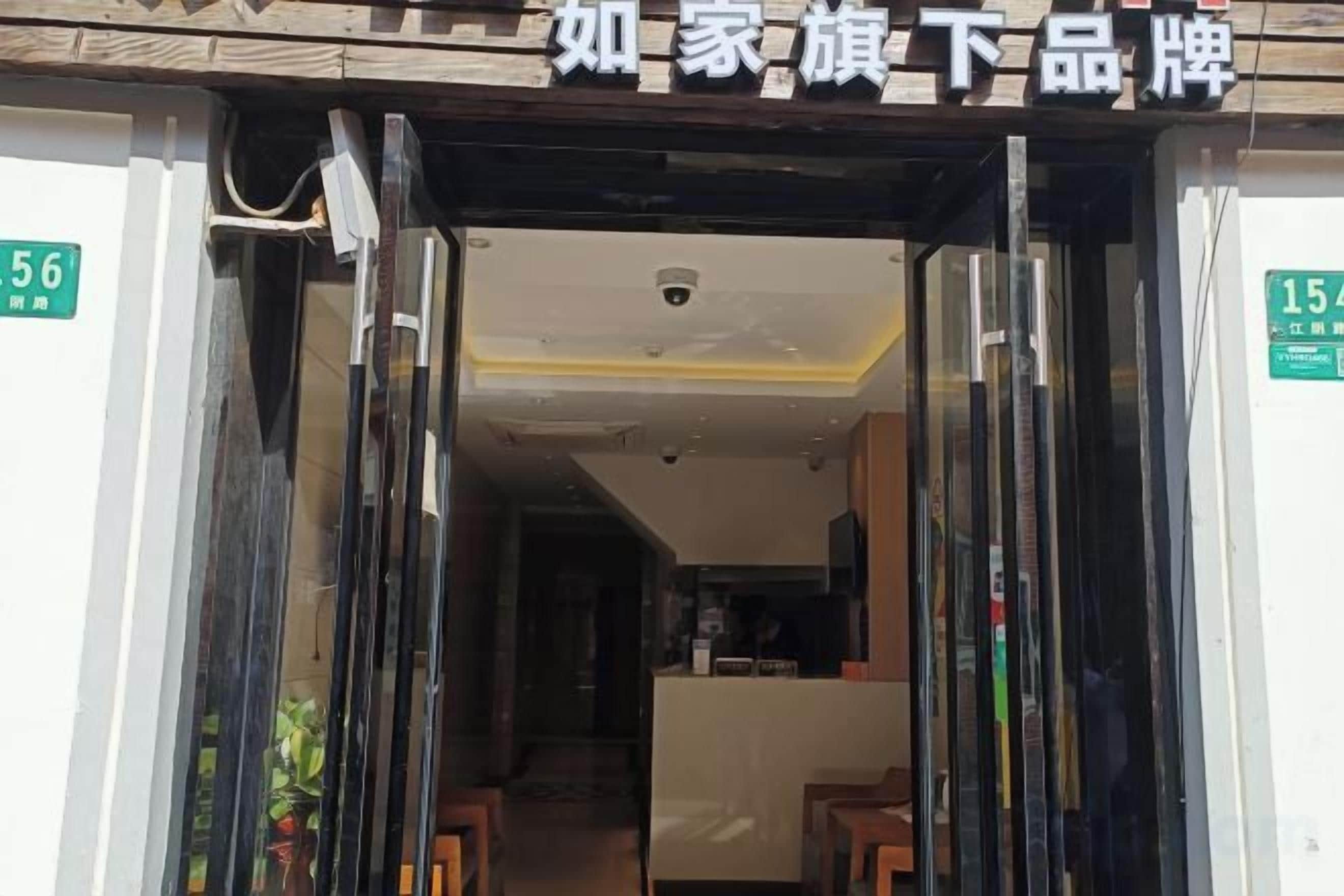 Entrada de hotel con mostrador de recepción y pasillo visible que conduce al interior.
