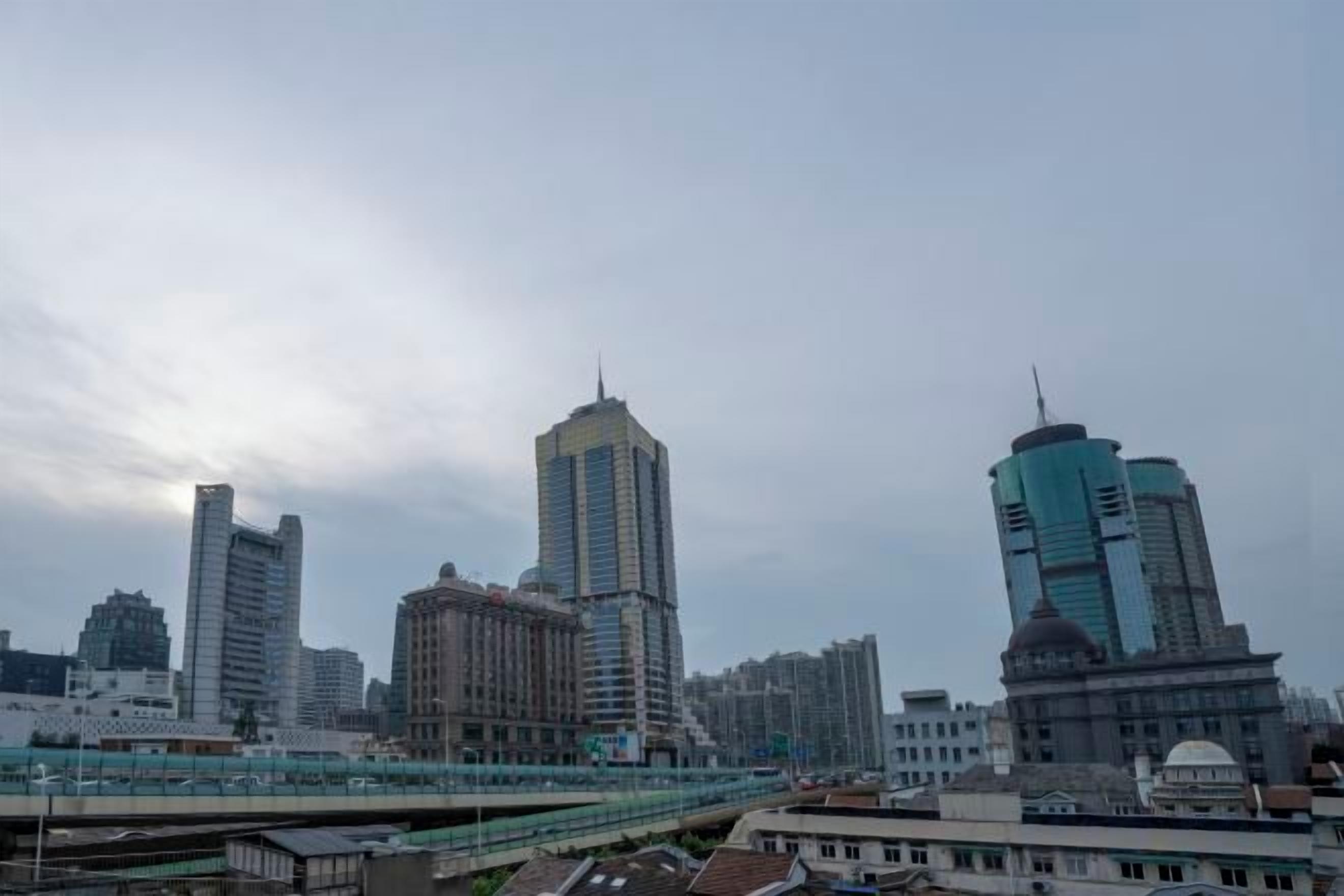 A cityscape with high-rise buildings and a bridge.